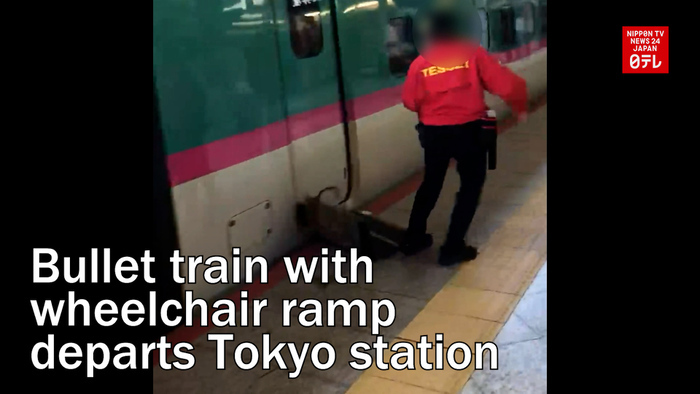 Bullet train with wheelchair ramp departs Tokyo station