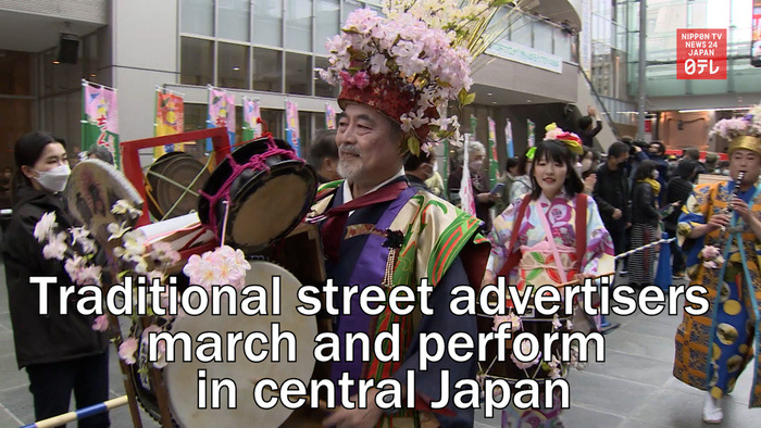 Traditional street advertisers march and perform in central Japan