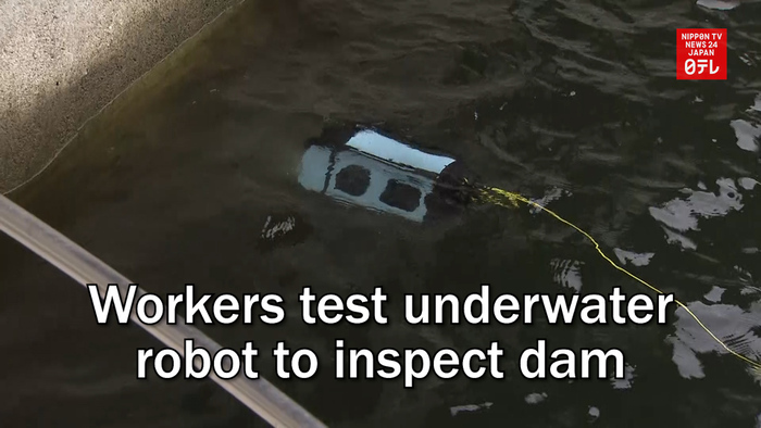 Workers test underwater robot to inspect dam