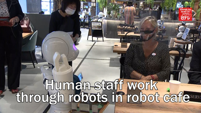 Human staff work through robots in robot cafe