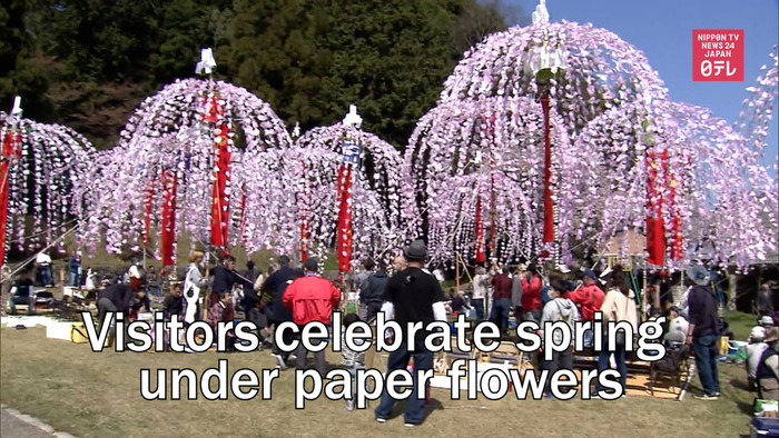 Visitors celebrate spring under paper flowers