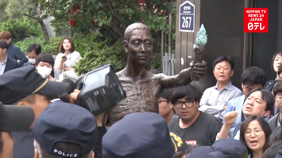 Protesters, police face off over statue of drafted worker